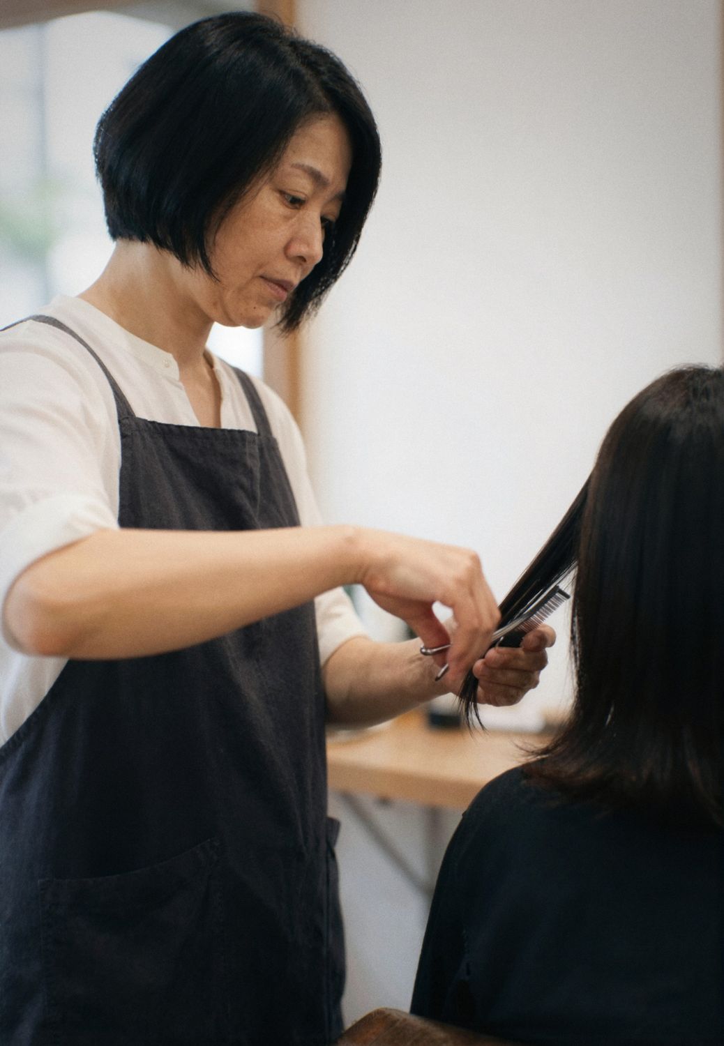 お客様の髪をカットする代表の七尾 さき